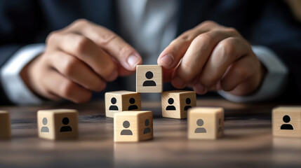 Naklejka premium A human resources manager is putting wooden cubes with human icons on a blue table in the style of a business team building concept