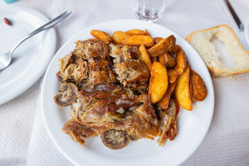 Juicy roasted lamb meat with tasty potato, traditional Greek cuisine, served in a rustic restaurant, showcasing authentic flavors