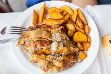 Juicy roasted lamb meat with tasty potato, traditional Greek cuisine, served in a rustic restaurant, showcasing authentic flavors