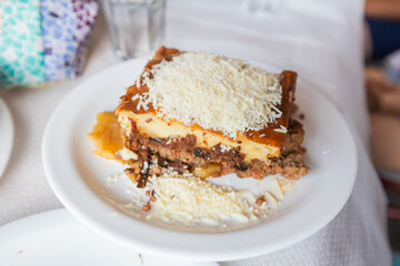 Traditional Greek moussaka served on a rustic restaurant table, showcasing rich, layered Mediterranean flavors