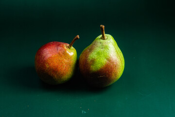 Ripe pears in a string bag on a green background