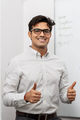 Thumbs up Positve Attitude Smiling Business Person Giving Thumbs Up in Office with Graph Board Showing Success Motivating.