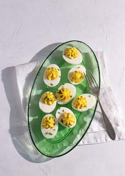 Deviled eggs beautifully arranged on a glass plate from above