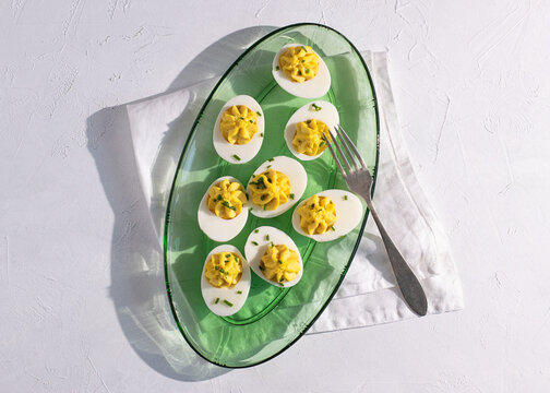 Top view of deviled eggs served on a green glass plate