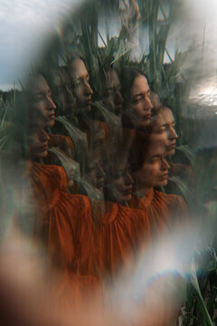 Surreal portrayal of brunette woman with multiple exposures in a field