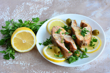 a plate of fish with lemon slices top view