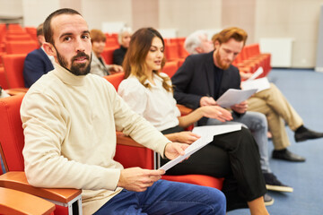 Audience with forms during business conference at auditorium