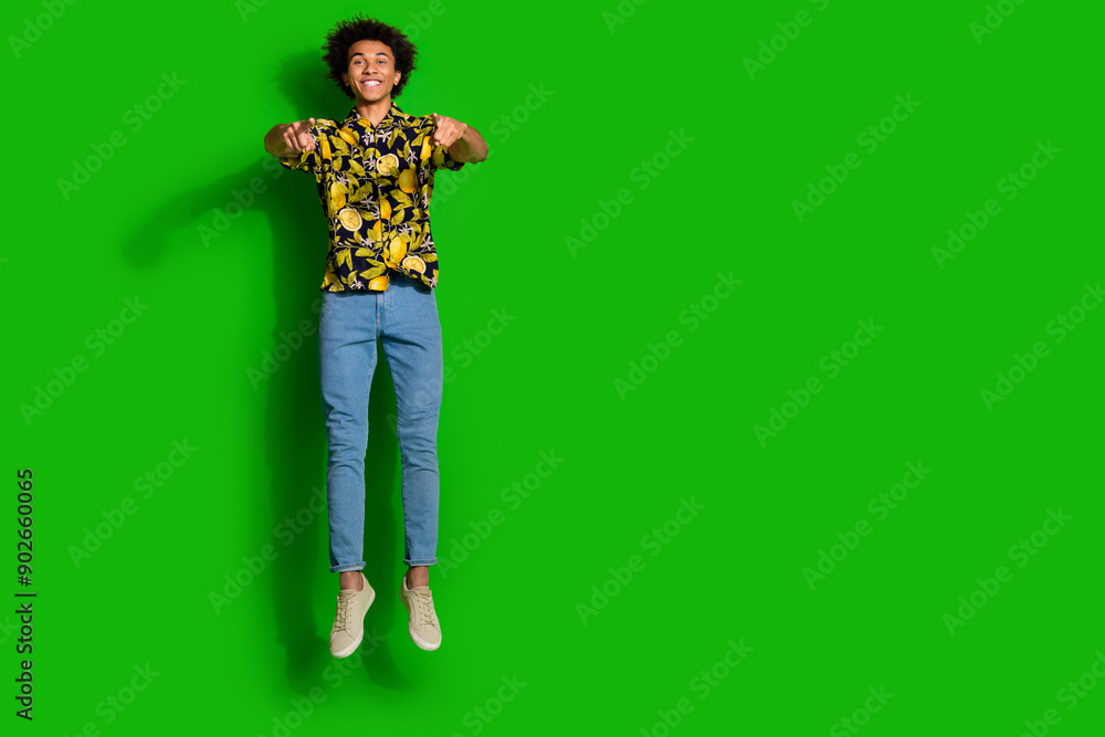 Poster Photo of cheerful positive man wear stylish summer print clothes jump up empty space isolated on green color background