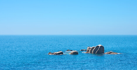 Ocean, rocks and travel in outdoor nature, destination and peace in environment on sea vacation. Water, stone and calm beach on weekend trip, tropical island and holiday wallpaper of Bali skyline