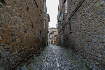 Quaint narrow alley with stone-paved path and historic buildings in Santillana del Mar, Spain. Perfect for travel, architecture, and cultural themes