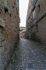 Quaint narrow alley with stone-paved path and historic buildings in Santillana del Mar, Spain. Perfect for travel, architecture, and cultural themes