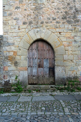 Fototapeta premium Quaint narrow alley with stone-paved path and historic buildings in Santillana del Mar, Spain. Perfect for travel, architecture, and cultural themes