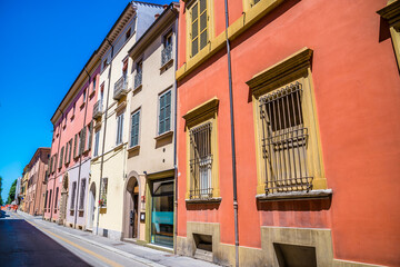 Naklejka premium A view up a main street with colourful buildings in Imola, Italy in summertime