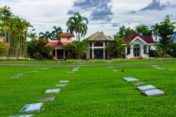 The serene cemetery, enclosed by lush greenery, exuded a tranquil and verdant atmosphere.






