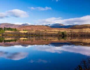 Rural agricultural landscape of mountains  reflected in Scottish loch 
