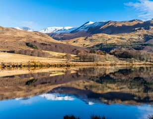 Obraz premium Rural agricultural landscape of mountains reflected in Scottish loch 
