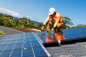Solar panel technician with drill installing solar panels