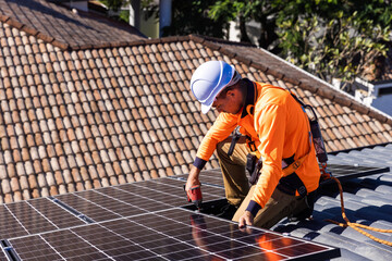 Solar panel technician with drill installing solar panels