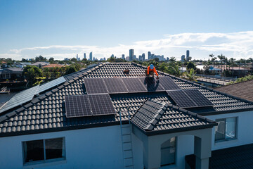 Solar panels and technician on luxury waterfront home