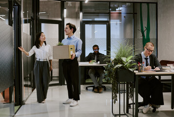 Wide shot of friendly young Asian HR manager demonstrating office to new employee, copy space