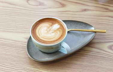 Hot latte art coffee cup on table in coffee shop