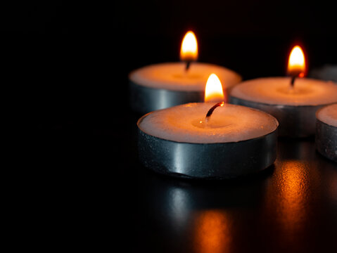 Candles shining on dark background with customizable space for text of message. Copy space concept - Powered by Adobe