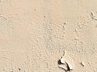 Cracked beige paint on the wall of a house. Abstract background