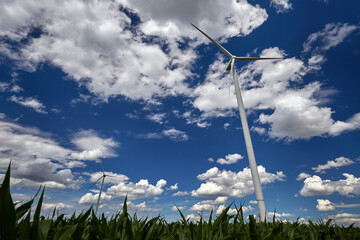 Elektrownia wiatrowa - wiatrak na tle błękitnego nieba z chmurami © arteffect.pl