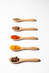 Multiple spices on the wooden spoons, chili, spice mix, turmeric, cumin, Italian herbs