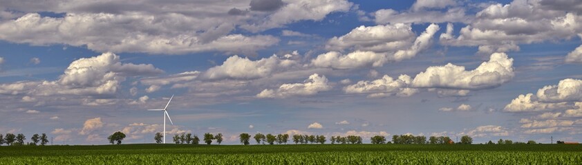 Elektrownia wiatrowa - wiatraki na tle błękitnego nieba z chmurami © arteffect.pl