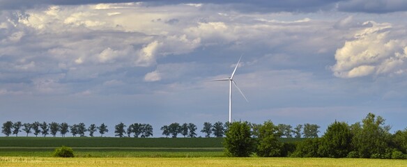 Elektrownia wiatrowa - wiatraki na tle błękitnego nieba z chmurami © arteffect.pl