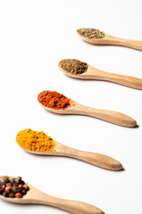 Multiple spices on the wooden spoons, chili, spice mix, turmeric, cumin, Italian herbs