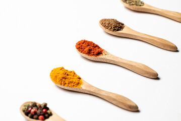 Multiple spices on the wooden spoons, chili, spice mix, turmeric, cumin, Italian herbs