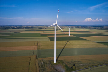 Elektrownia wiatrowa - wiatraki na tle błękitnego nieba z chmurami © arteffect.pl