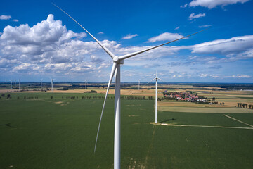 Elektrownia wiatrowa - wiatraki na tle błękitnego nieba z chmurami © arteffect.pl