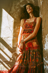 A woman is wearing a colorful dress and is posing for a photo