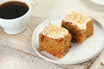 Slice of homemade carrot cake in white plate on white background
