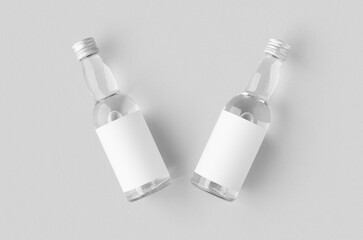 Miniature spirits, liquor bottle mockup. Clear glass and liquid with a blank label.
