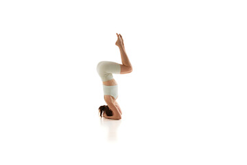 Woman enhances her stability and focus, during yoga session against white studio background. Strength and mental clarity. Concept of beauty, mindfulness and balance, concentration. Ad