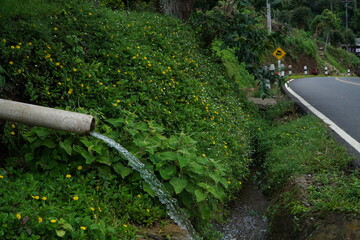 A clean mountain roadside Drain pipe in northern Thailand.Water pipes flow near the road.