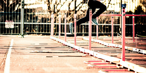 The Hurdler's Graceful Leap: An athlete clearing a row of high hurdles with ease and precision.