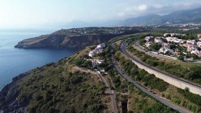 Aerial cinematographic view of gray rocks and blue sea on the Calabrian coast near Scalea city.