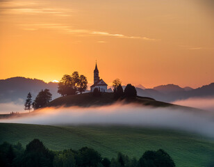 Fototapeta premium A picturesque church on a hill with a stunning sunrise and fog-covered valley in the background