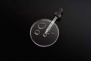 Petri dish with pipette on black background. Petri dish with liquid serum or gel. Top view