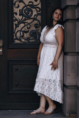 Naklejka premium woman in a white lace dress stands in front of a door