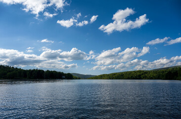 Vlasina lake scenery with beautiful clouds in the blue sky. Beautiful semi-artificial lake in Southeast Serbia.  The beautiful blue color of the water.