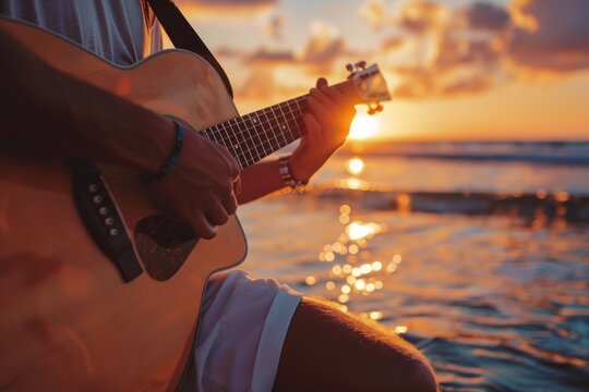 Close up young man playing guitar at sunset at the beach. Relaxed beautiful man playing guitar at beach - Powered by Adobe