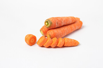 Whole carrots sliced ​​pieces, all in bright orange color prepared for cooking or for use in dishes such as salads or stir-fries isolated on white background
