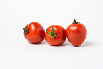 A small red tomato. Group of tomatoes isolated on white background.
