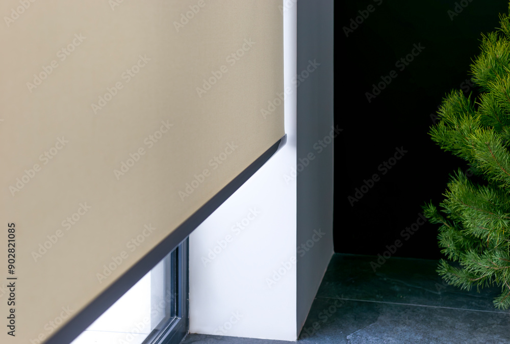 Aufkleber roller blinds on full height window. automated smart curtains indoors. a beige electric roller shade